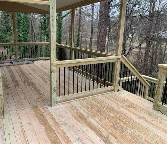 Wooden deck with covered area, handrail and baluster fence