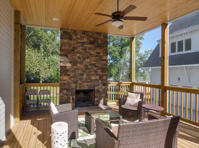 Covered porch with fireplace and wicker furniture