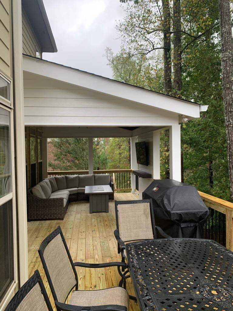 Outdoor dining area with grill in sunroom